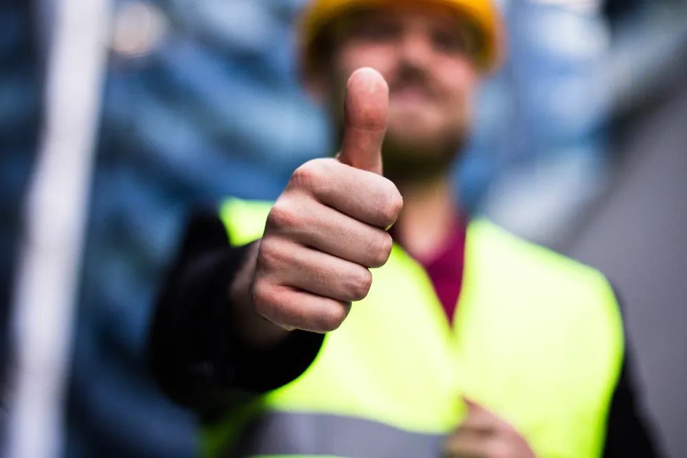 Construction worker giving a thumbs up on-site, symbolizing Restorations Unlimited’s confident walkthrough process and commitment to building with strategy and precision