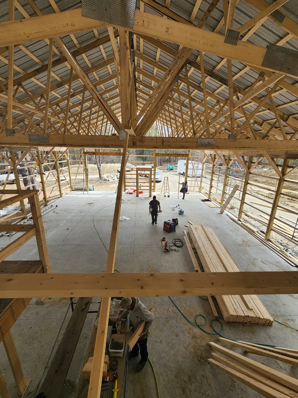 Crew members working inside a large timber-framed commercial structure, representing Restorations Unlimited’s expertise in designing and building strategic additions that enhance business operations and future growth.