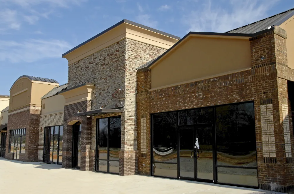 Exterior view of a newly constructed brick commercial building with large storefront windows, representing Restorations Unlimited’s expertise in delivering cost-effective commercial additions that enhance business functionality and visual appeal.