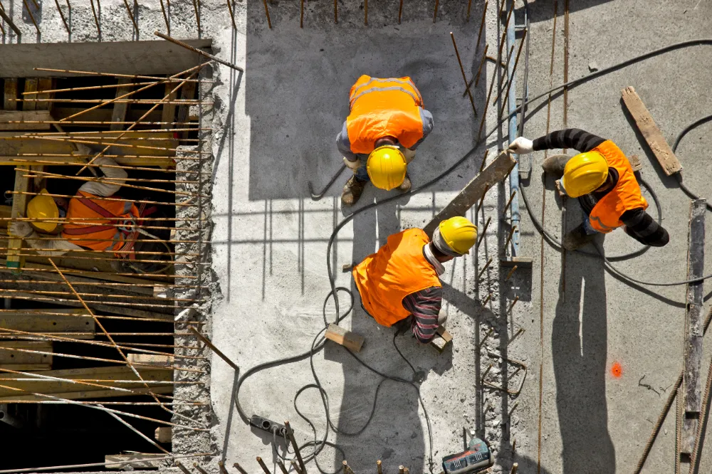 Construction crew in safety gear repairing a commercial concrete structure from above, illustrating Restorations Unlimited’s precision repair services in Maine focused on lasting craftsmanship and minimal downtime.