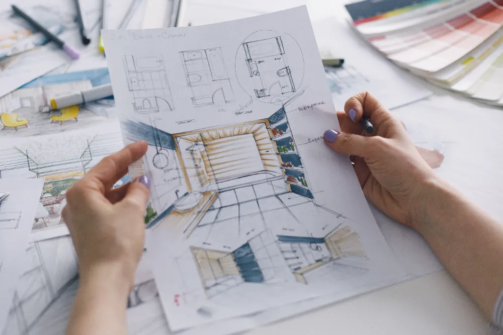 Architect reviewing detailed bathroom layout plans and color swatches—representing Restorations Unlimited’s full-service approach to efficient, design-driven bathroom remodeling solutions in Maine.