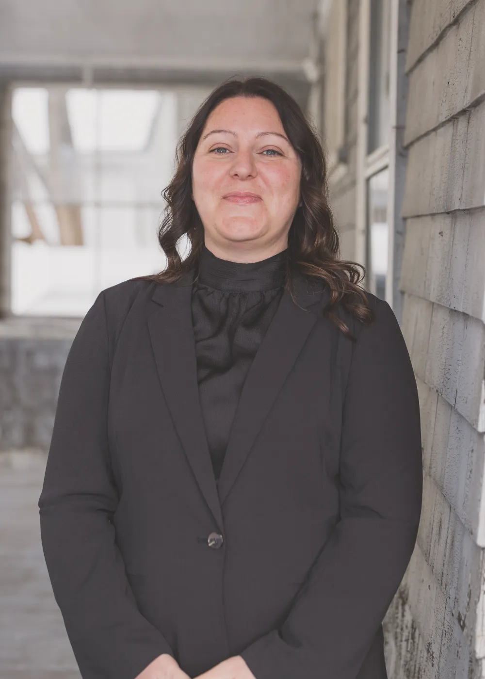 Melinda White of Restorations Unlimited standing outside in a black suit, representing her leadership, business expertise, and dedication to project design, client experience, and company operations.