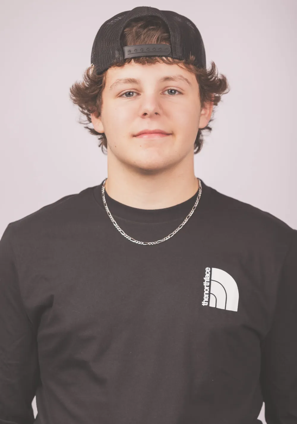 Brady Rolfe of Restorations Unlimited wearing a black shirt and cap, representing his steady focus, hands-on skill, and dedication to each construction project as part of the Maine-based crew.