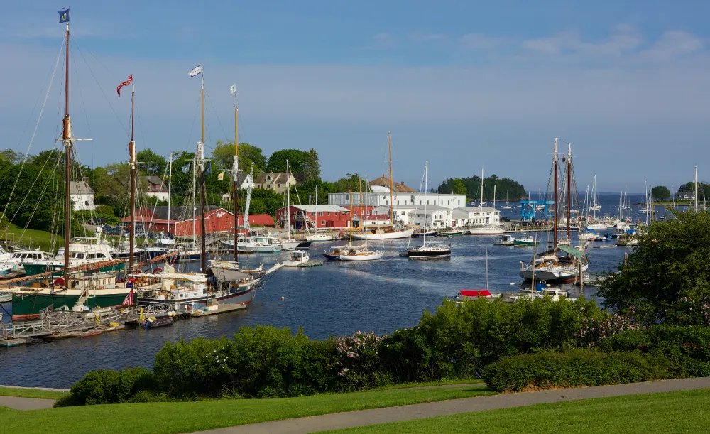 Scenic view of Camden Harbor with sailboats and waterfront buildings, representing Restorations Unlimited’s home addition services in Camden, Maine