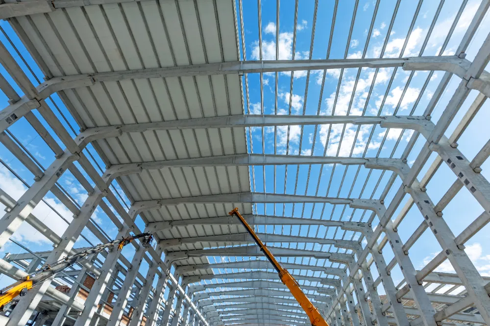 Crew installing a large metal roof structure under a blue sky in Bar Harbor, Maine, representing Restorations Unlimited’s roofing services