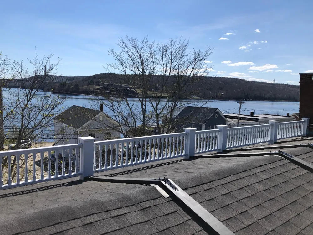 View from a newly installed commercial roof overlooking a waterfront landscape in Maine, showcasing Restorations Unlimited’s precision craftsmanship and durable roofing solutions built to withstand New England weather.