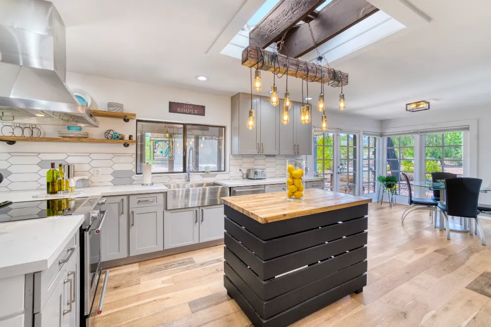 Stylish modern kitchen with rustic wood beams, open shelving, and natural light—showcasing Restorations Unlimited’s complete kitchen renovation craftsmanship for Maine homeowners seeking functional, high-end redesigns.