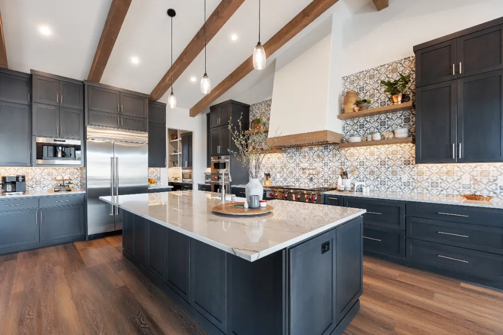 Modern kitchen with dark cabinetry, wood beams, and patterned backsplash—highlighting Restorations Unlimited’s balance of craftsmanship, functionality, and design in Maine kitchen remodels built around real life.