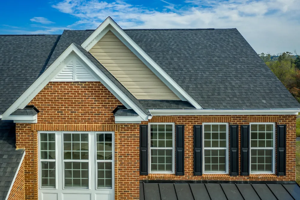 Close-up view of a newly installed asphalt shingle roof on a brick home—demonstrating Restorations Unlimited’s durable residential roofing craftsmanship in Maine.