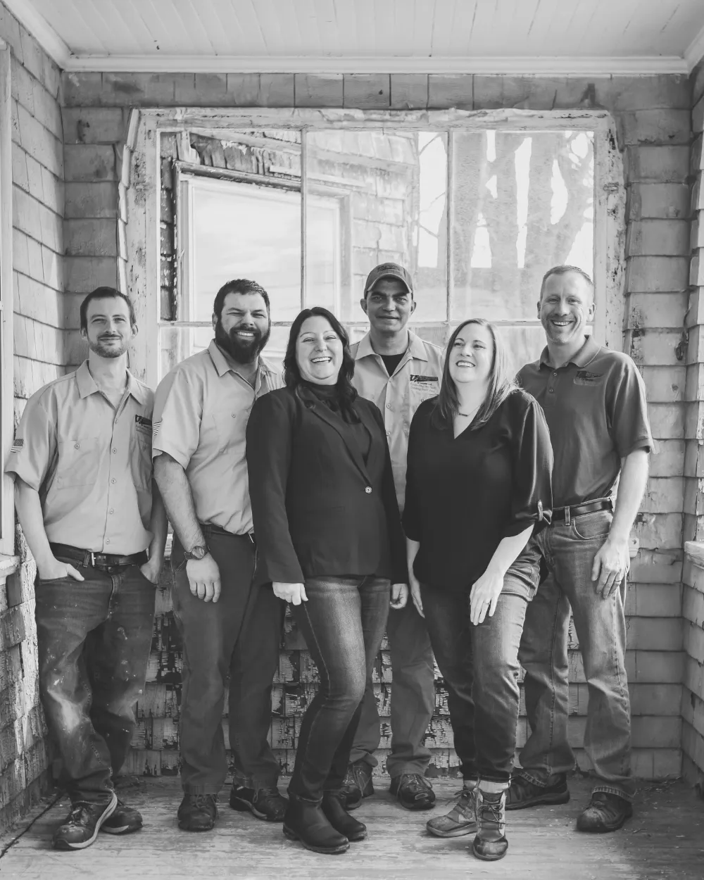 The Restorations Unlimited team standing together at a job site, smiling and showcasing their united, family-like crew dedicated to quality craftsmanship and collaboration