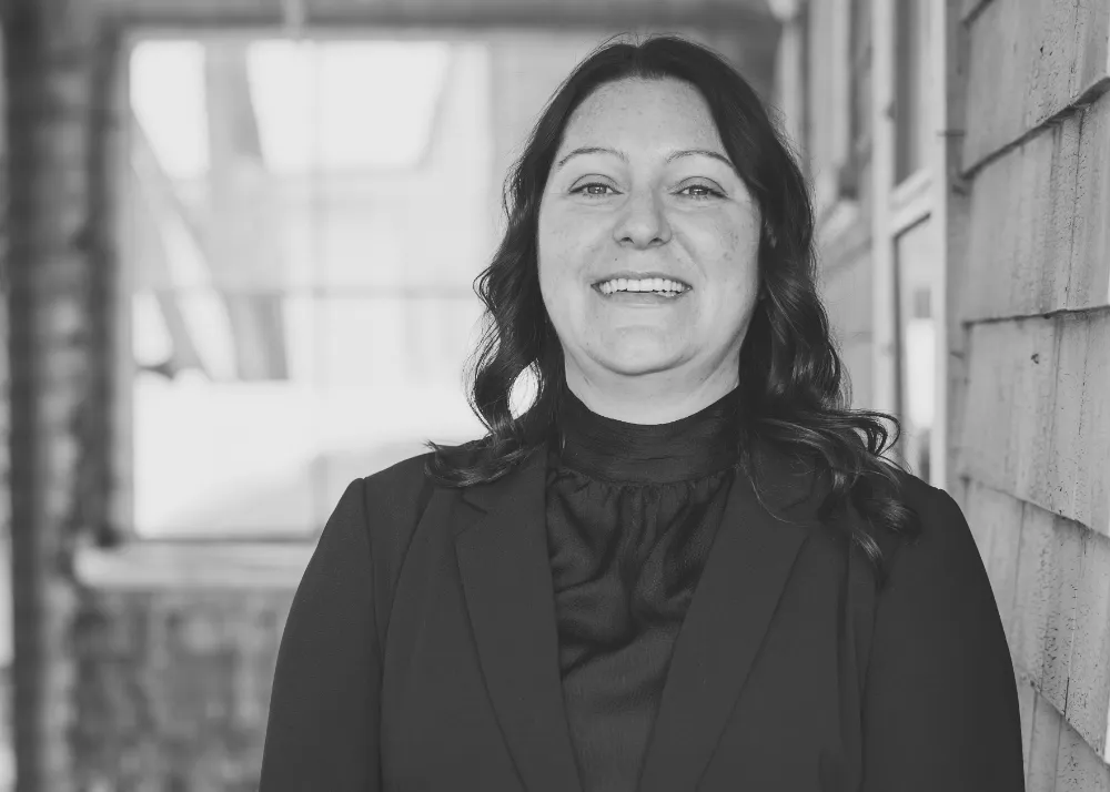 Melinda from Restorations Unlimited smiling outside a project site, representing the company’s design process that transforms client visions into blueprints